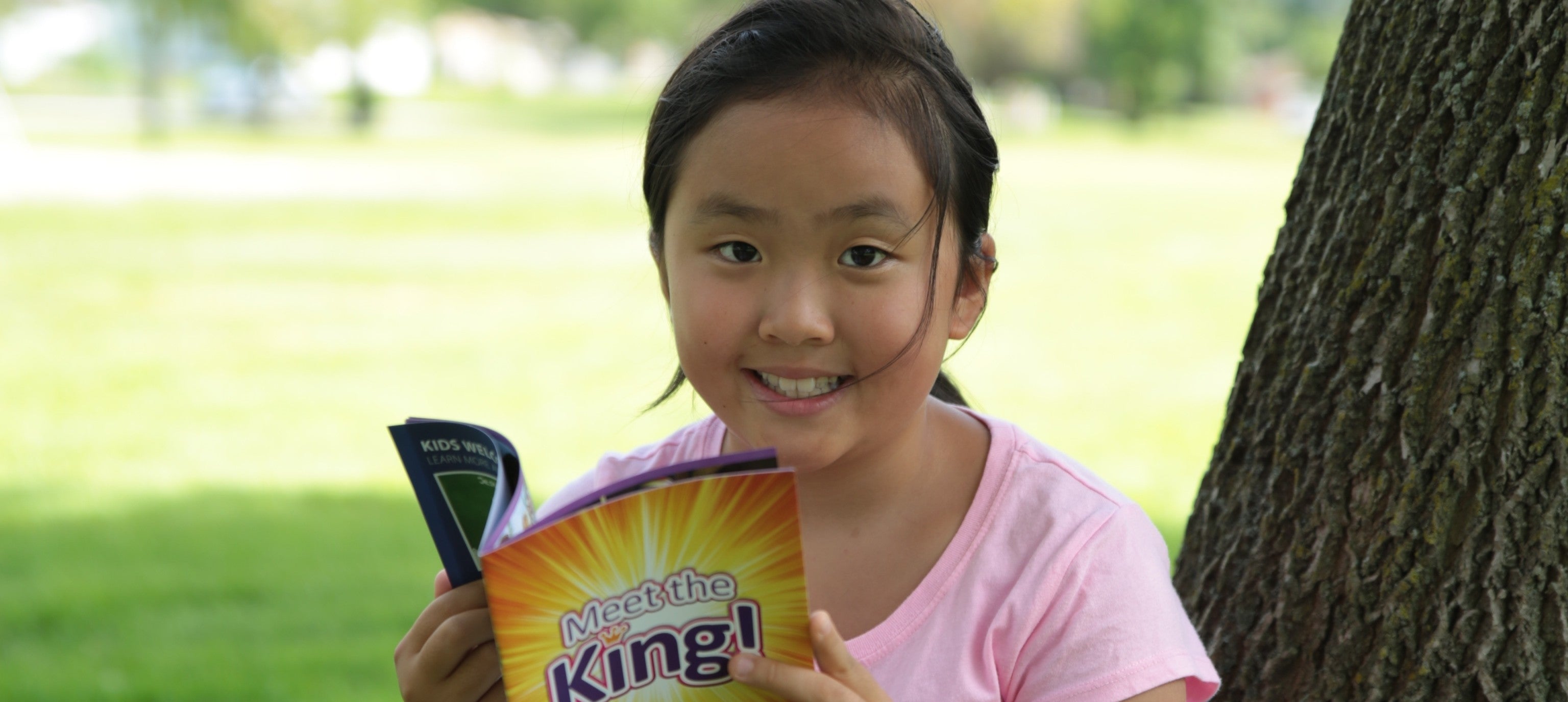 Young girl holding a Nestle King! chocolate bar outdoors.